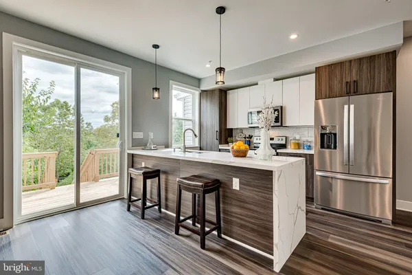 a kitchen with kitchen island a large counter space a sink appliances and cabinets