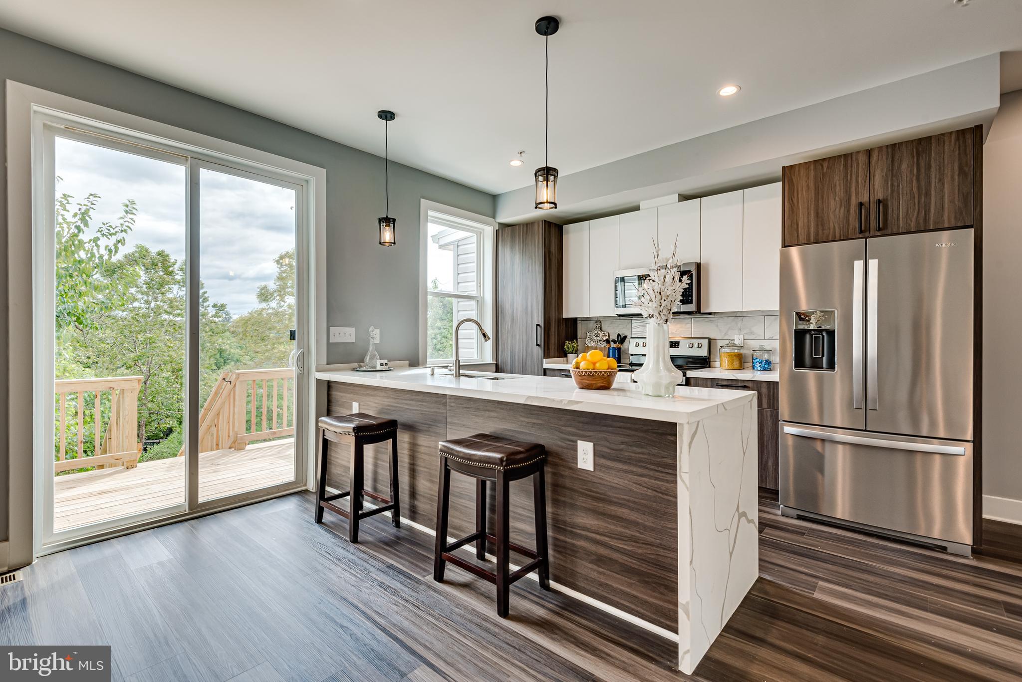 3830 First Street Southeast Washington, DC 20032 - Photo 11 of 49 a kitchen with kitchen island a large counter space a sink appliances and cabinets