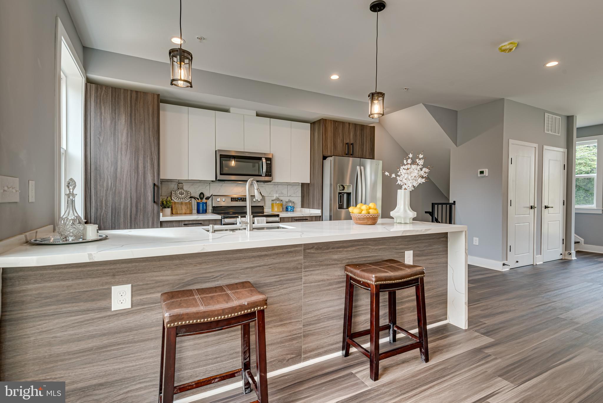 3830 First Street Southeast Washington, DC 20032 - Photo 12 of 49 a kitchen with stainless steel appliances granite countertop a sink a stove a refrigerator and island with wooden floor