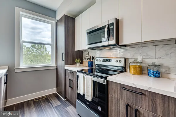 a kitchen with stainless steel appliances a stove microwave and sink