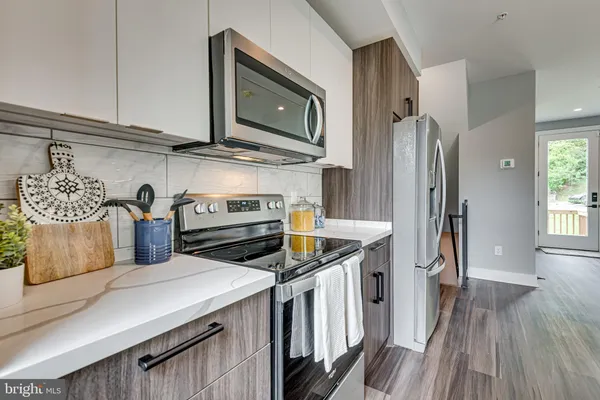 a kitchen with stainless steel appliances granite countertop a stove a sink and a refrigerator