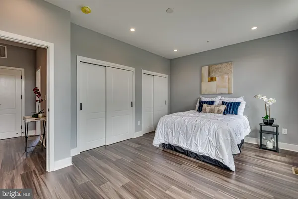 a spacious bedroom with a bed and a wooden floor