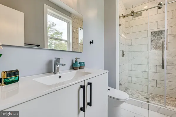 a bathroom with a sink a toilet and a mirror