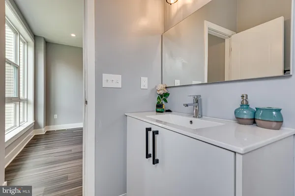 a view of cabinets a sink and dishwasher with wooden floor