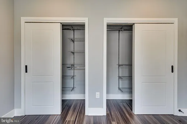 a view of walk in closet with wooden floor and furniture