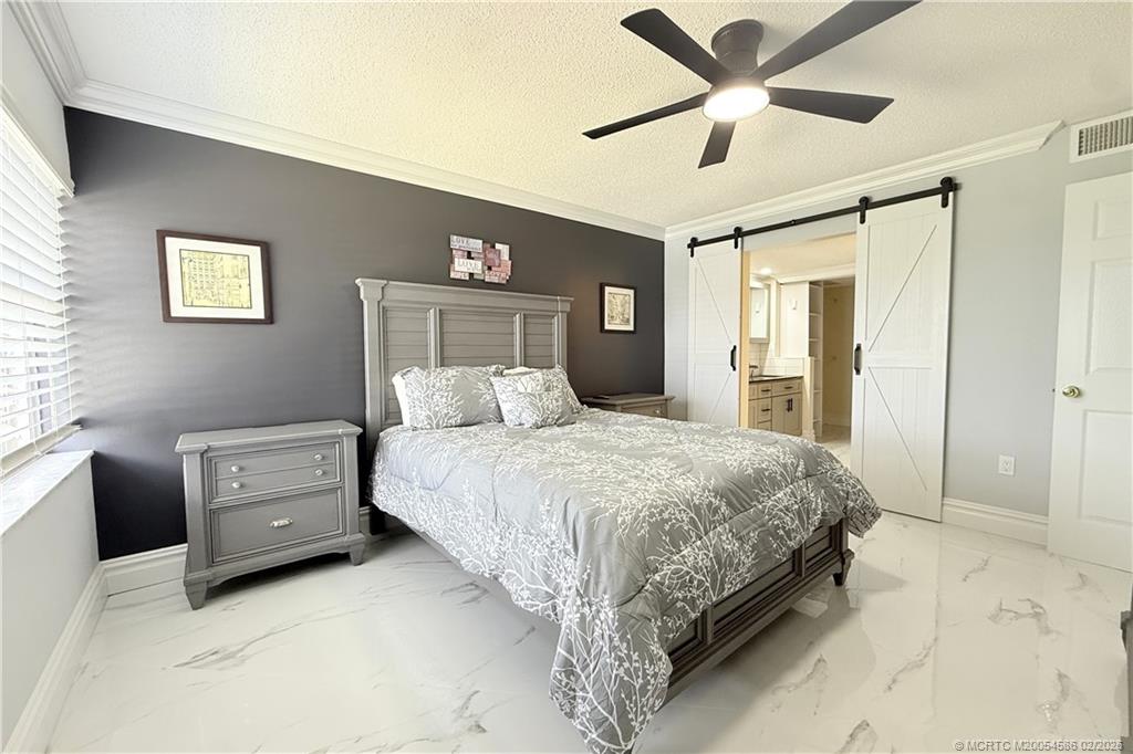 1950 Southwest Palm City Road, Unit 3309 Stuart, FL 34994 - Photo 16 of 32 a bedroom with a bed and a chandelier