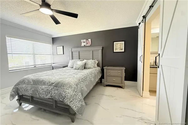a bedroom with a bed and ceiling fan