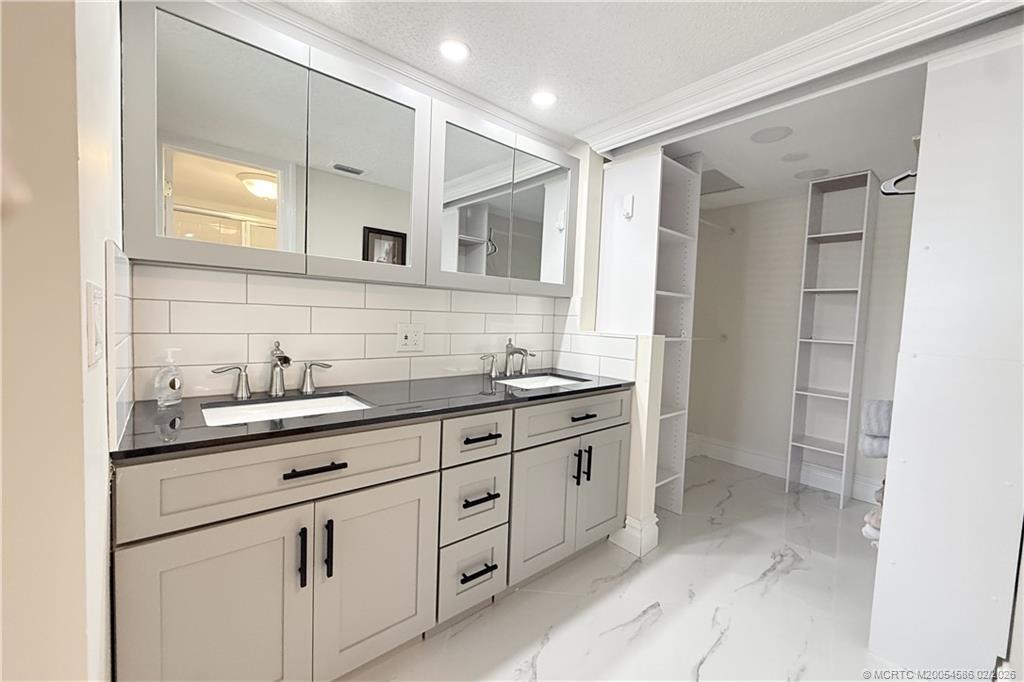1950 Southwest Palm City Road, Unit 3309 Stuart, FL 34994 - Photo 20 of 32 a spacious bathroom with a granite countertop sink mirror and double