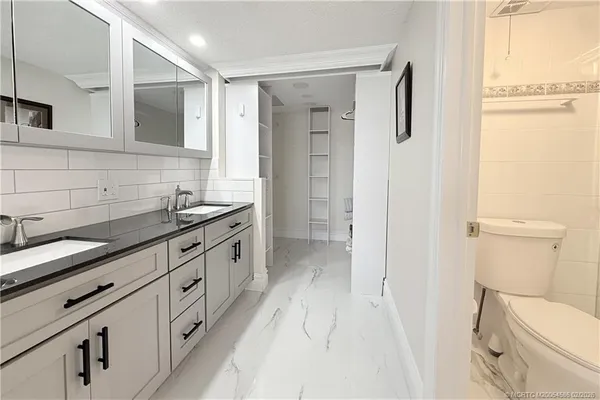a bathroom with a granite countertop sink toilet and shower