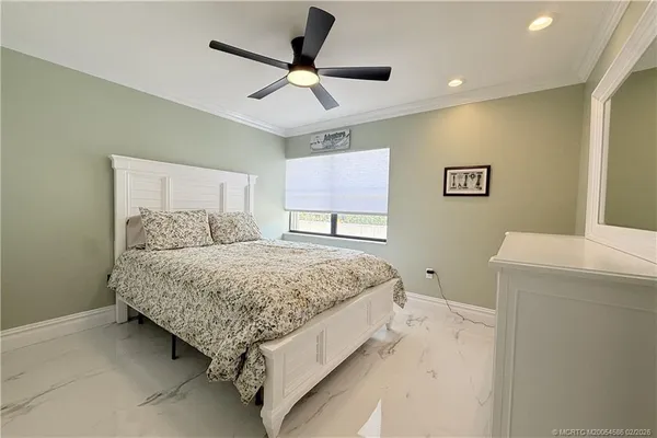 a spacious bedroom with a bed and a ceiling fan