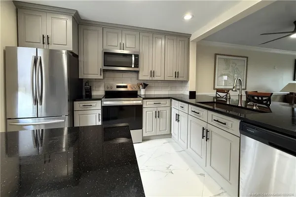 a kitchen with stainless steel appliances granite countertop a stove a sink and a refrigerator