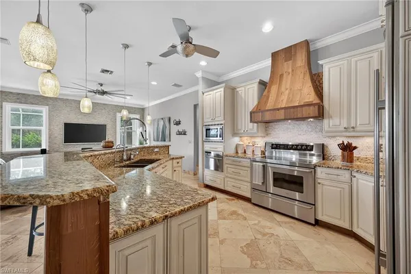 a kitchen with stainless steel appliances granite countertop a sink a stove and a refrigerator