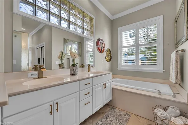 a bathroom with a granite countertop tub a sink and a large mirror
