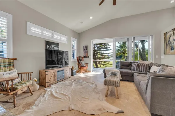 a living room with furniture large window and flat screen tv