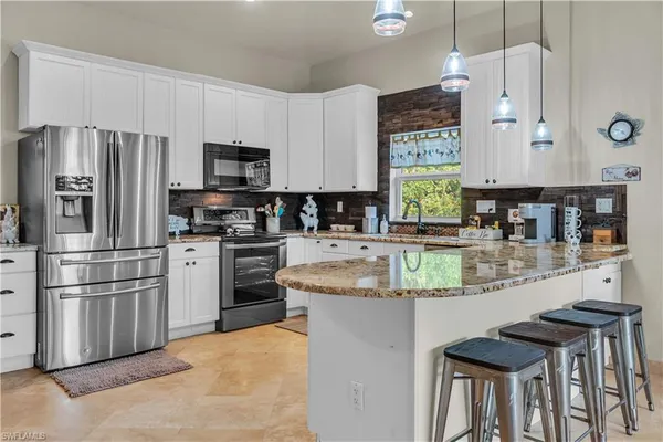 a kitchen with stainless steel appliances granite countertop a stove refrigerator sink and cabinets