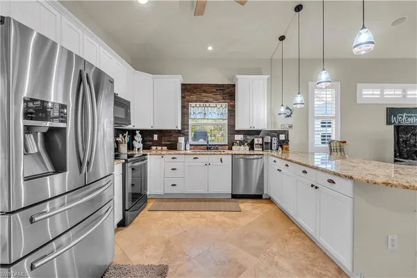 a kitchen with granite countertop a refrigerator stove top oven and sink
