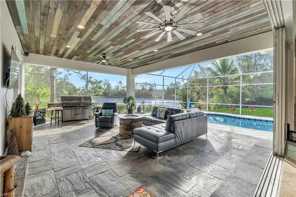 a living room with patio furniture and a floor to ceiling window