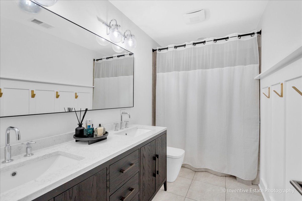 305 Clinton Avenue Elmhurst, IL 60126 - Photo 18 of 31 a bathroom with a double vanity sink and a mirror