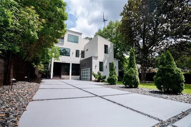 a front view of a house with a yard and trees