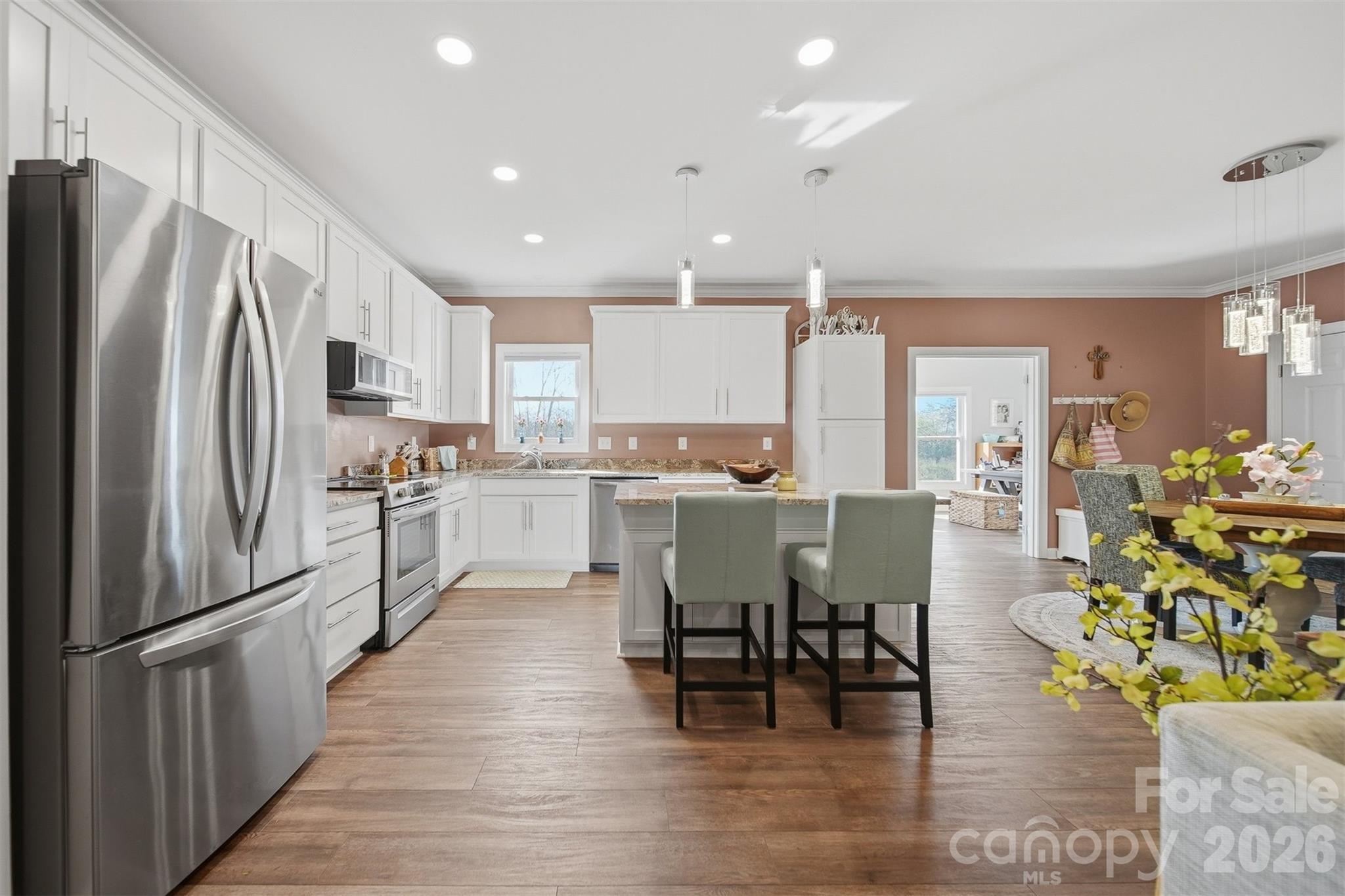 976 Amherst Road Morganton, NC 28655 - Photo 12 of 38 a kitchen with stainless steel appliances granite countertop a refrigerator a stove top oven and a dining table with wooden floor