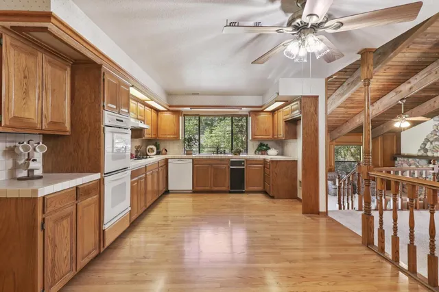a kitchen with stainless steel appliances a stove top oven a sink a refrigerator and cabinets