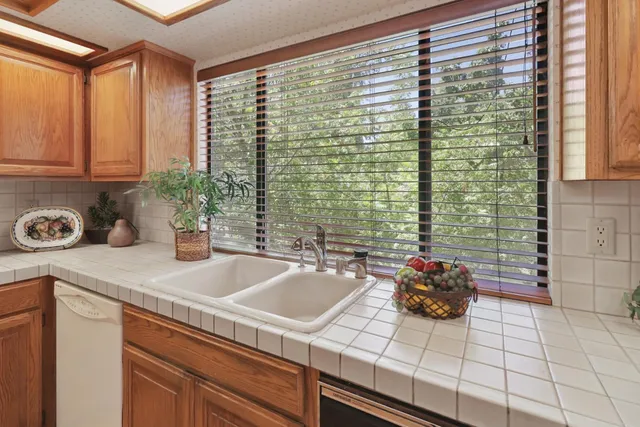 a kitchen with stainless steel appliances granite countertop a sink a stove and a refrigerator