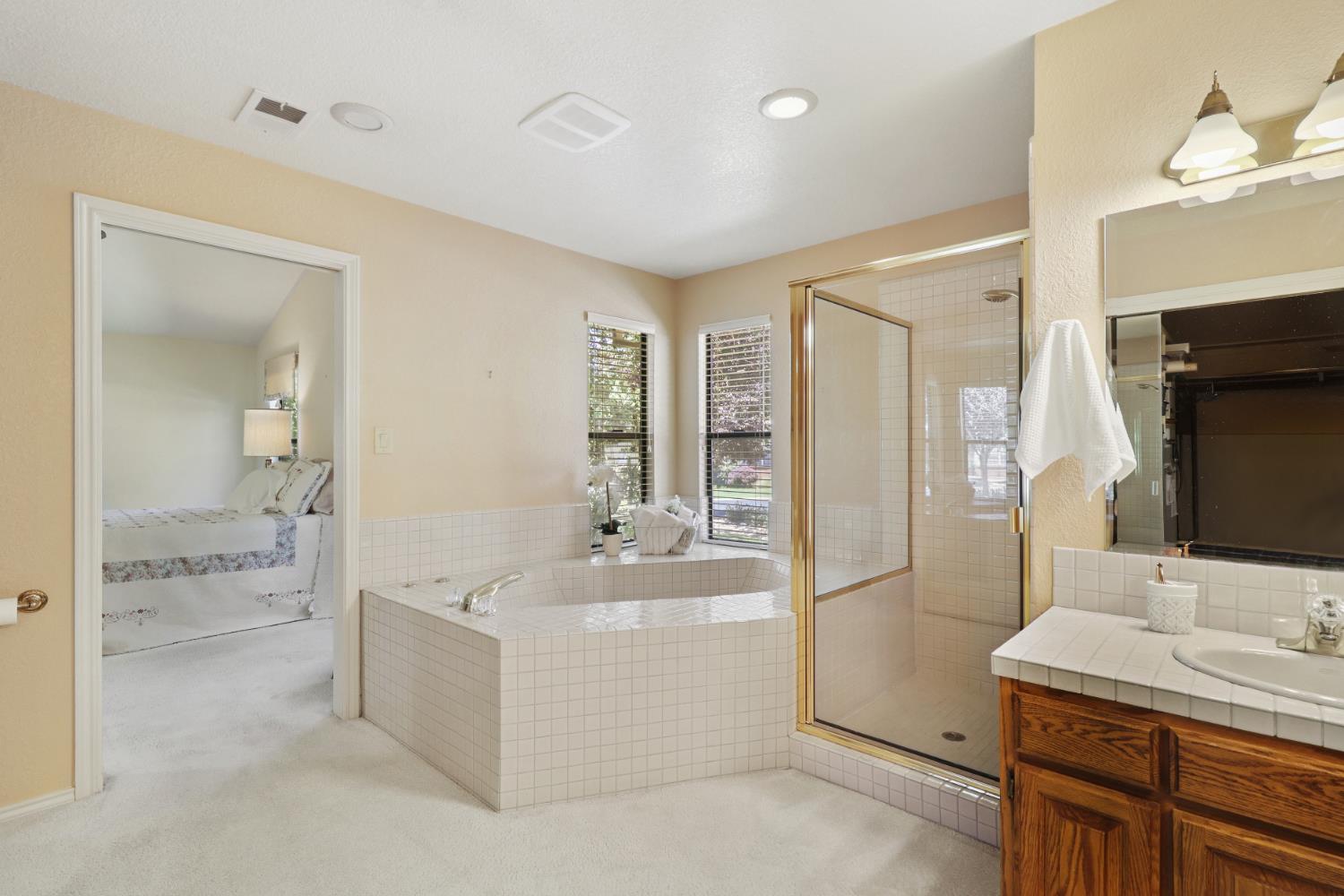 6798 Terreno Drive Rancho Murieta, CA 95683 - Photo 44 of 63 a bathroom with a sink a tub and a mirror