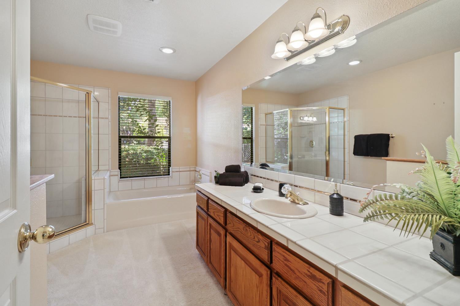 6798 Terreno Drive Rancho Murieta, CA 95683 - Photo 46 of 63 a spacious bathroom with double vanity a sink a large mirror and shower