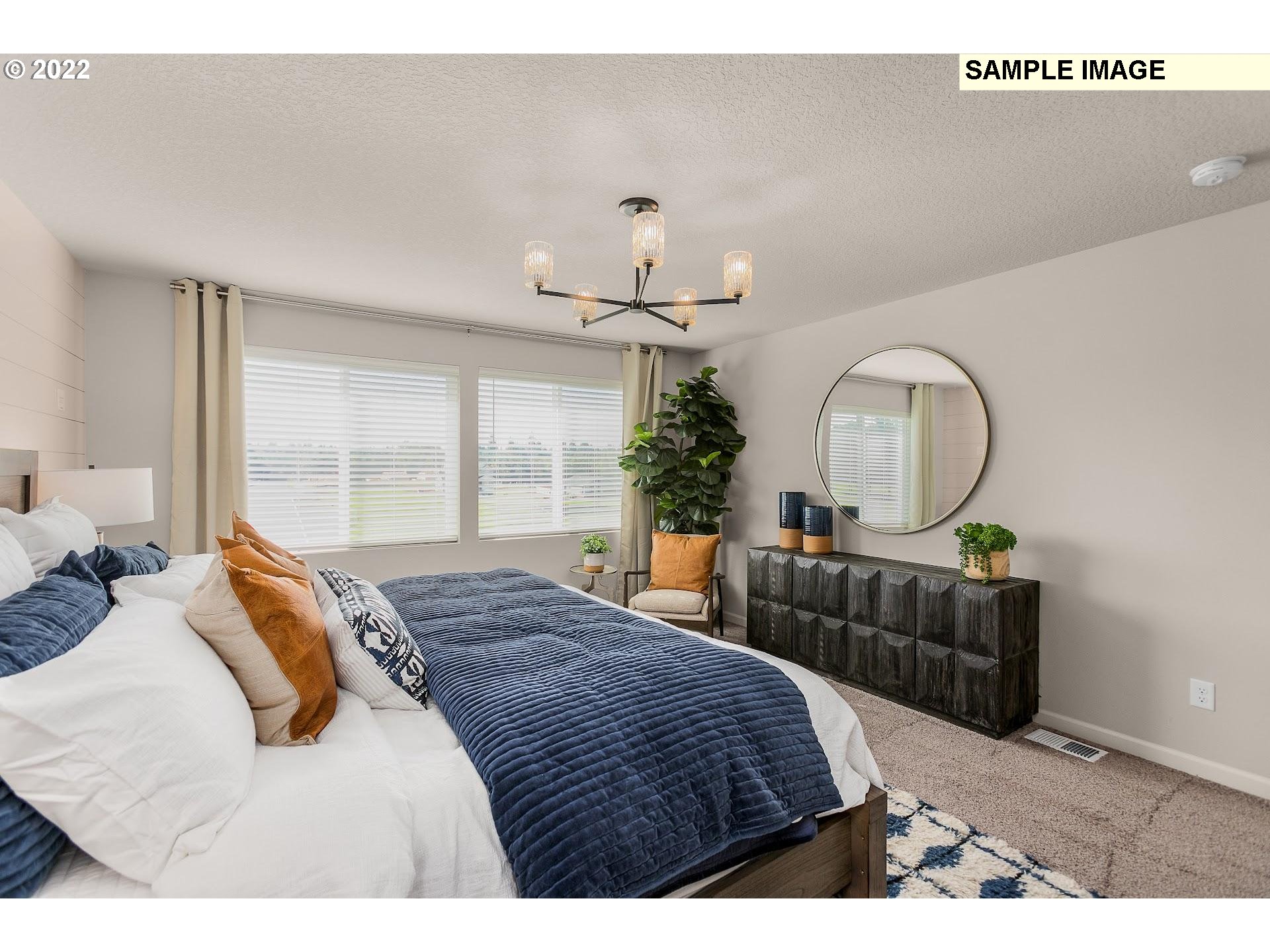 37413 Coho Street Sandy, OR 97055 - Photo 16 of 23 a bedroom with bed a chandelier and a window