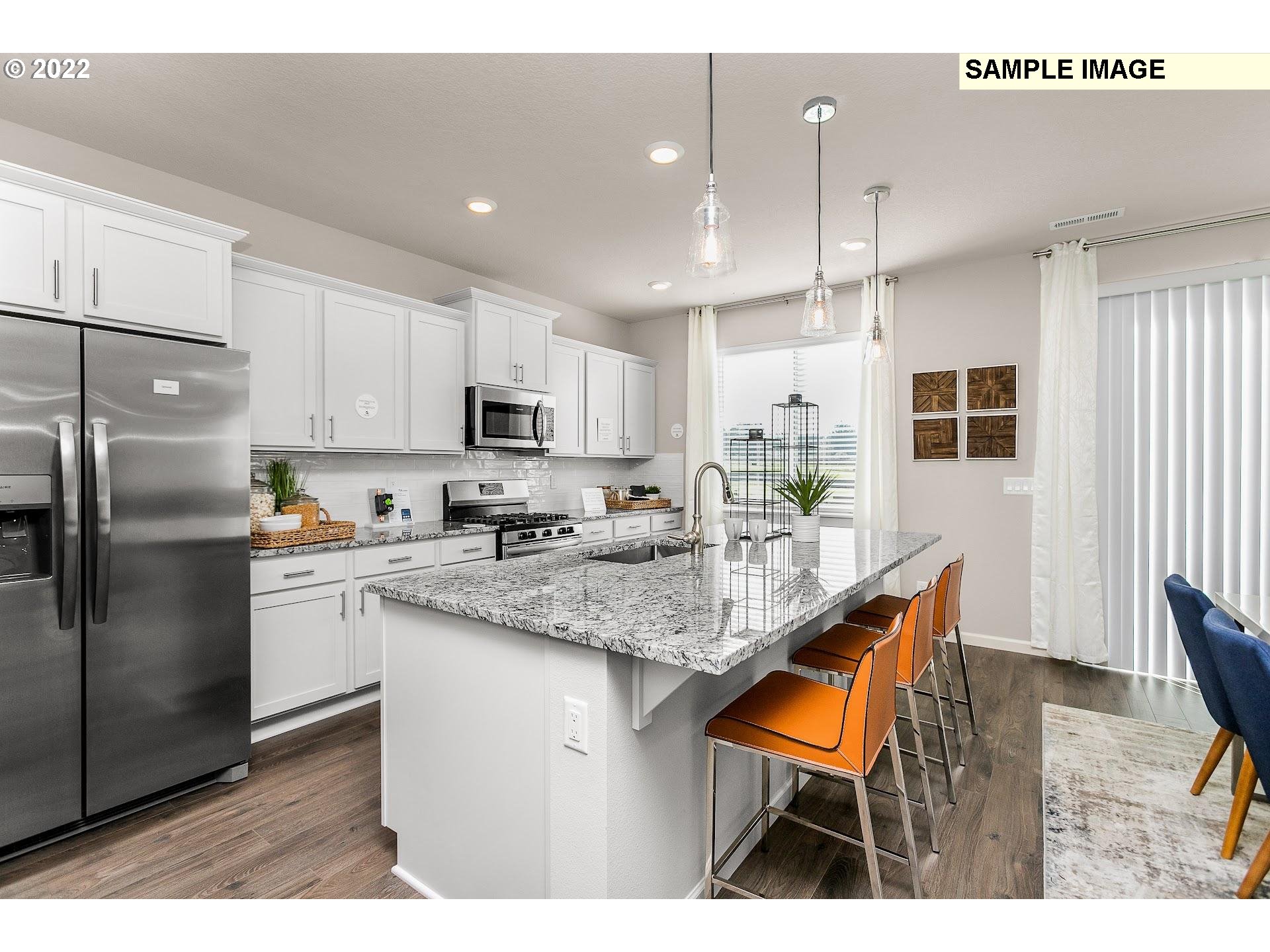 37413 Coho Street Sandy, OR 97055 - Photo 7 of 23 a kitchen with stainless steel appliances granite countertop a refrigerator a sink dishwasher a stove and white cabinets with wooden floor