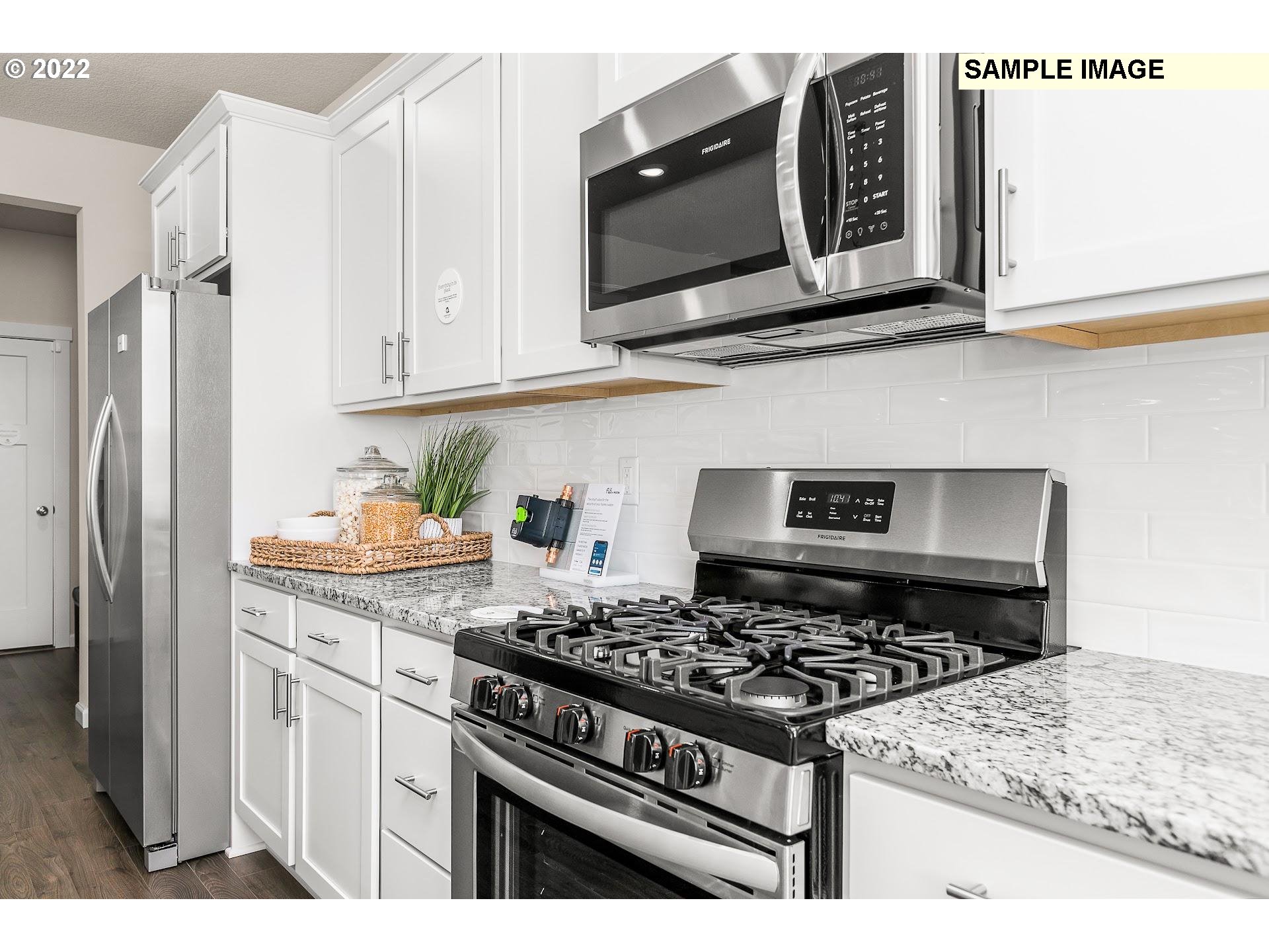 37413 Coho Street Sandy, OR 97055 - Photo 10 of 23 a kitchen with stainless steel appliances granite countertop white cabinets and black stove top oven with granite countertops