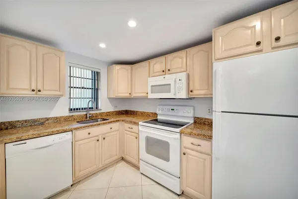 a kitchen with white cabinets and white appliances