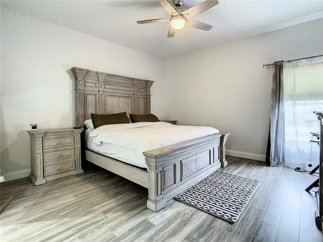 a bed sitting in a bedroom next to a window and a chandelier