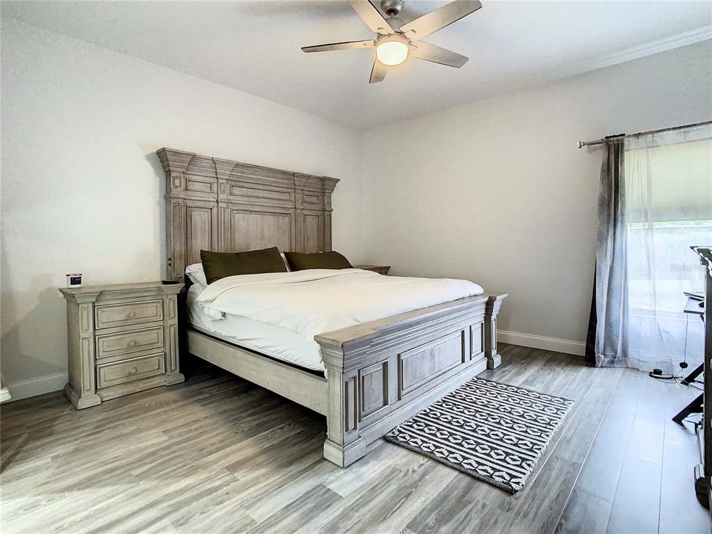 2841 Banyan Hill Lane Land O' Lakes, FL 34639 - Photo 11 of 20 a bed sitting in a bedroom next to a window and a chandelier