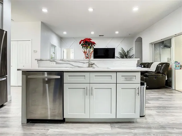 a kitchen with granite countertop a sink and white cabinets
