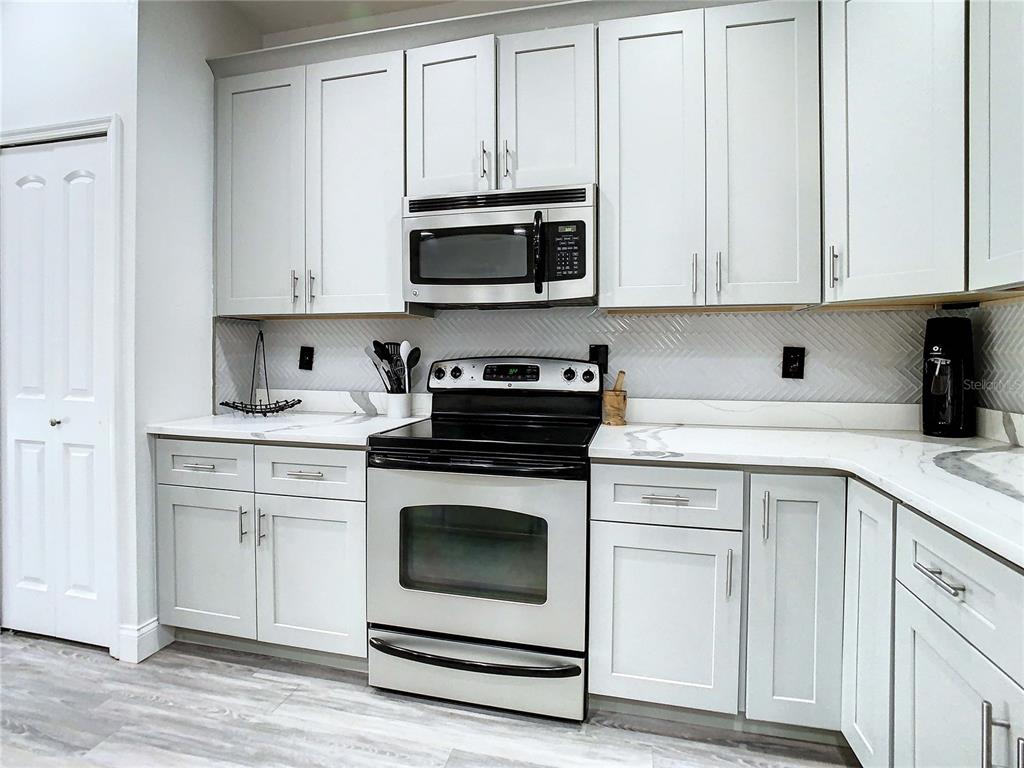 2841 Banyan Hill Lane Land O' Lakes, FL 34639 - Photo 8 of 20 a kitchen with white cabinets and white appliances