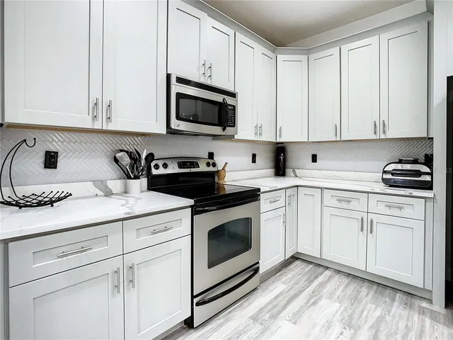 a kitchen with white cabinets and white appliances
