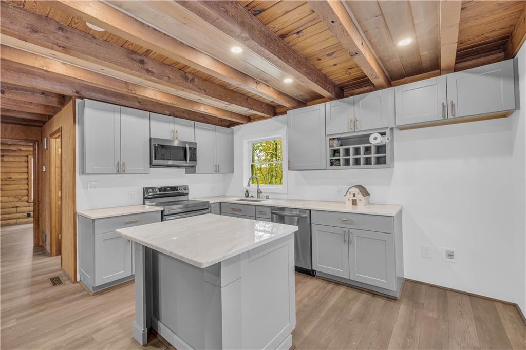 2885 Callie Still Road Lawrenceville, GA 30045 - Photo 28 of 79 a kitchen with a sink a stove cabinets and wooden floor
