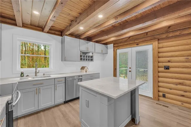 a view of a big room with wooden floor ceiling fan and windows