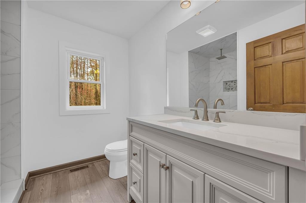 2885 Callie Still Road Lawrenceville, GA 30045 - Photo 38 of 79 a bathroom with a sink a toilet and a mirror
