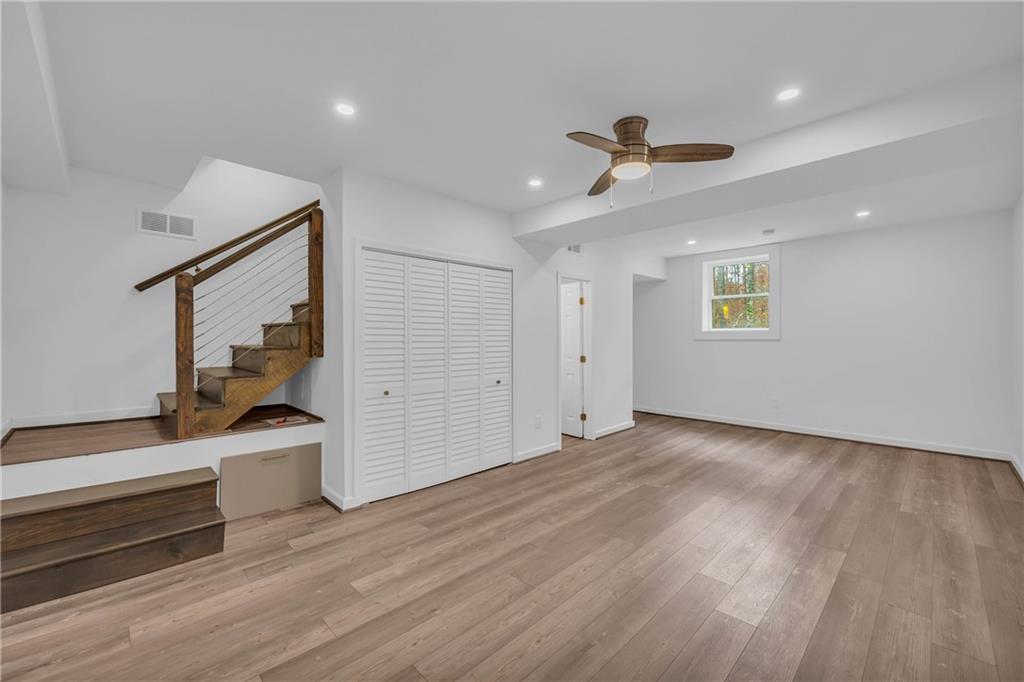 2885 Callie Still Road Lawrenceville, GA 30045 - Photo 41 of 79 a view of a big room with wooden floor ceiling fan and windows