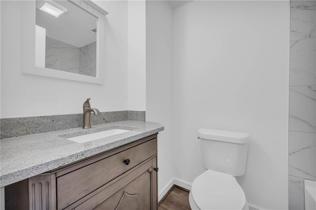 2885 Callie Still Road Lawrenceville, GA 30045 - Photo 44 of 79 a bathroom with a granite countertop toilet sink and mirror
