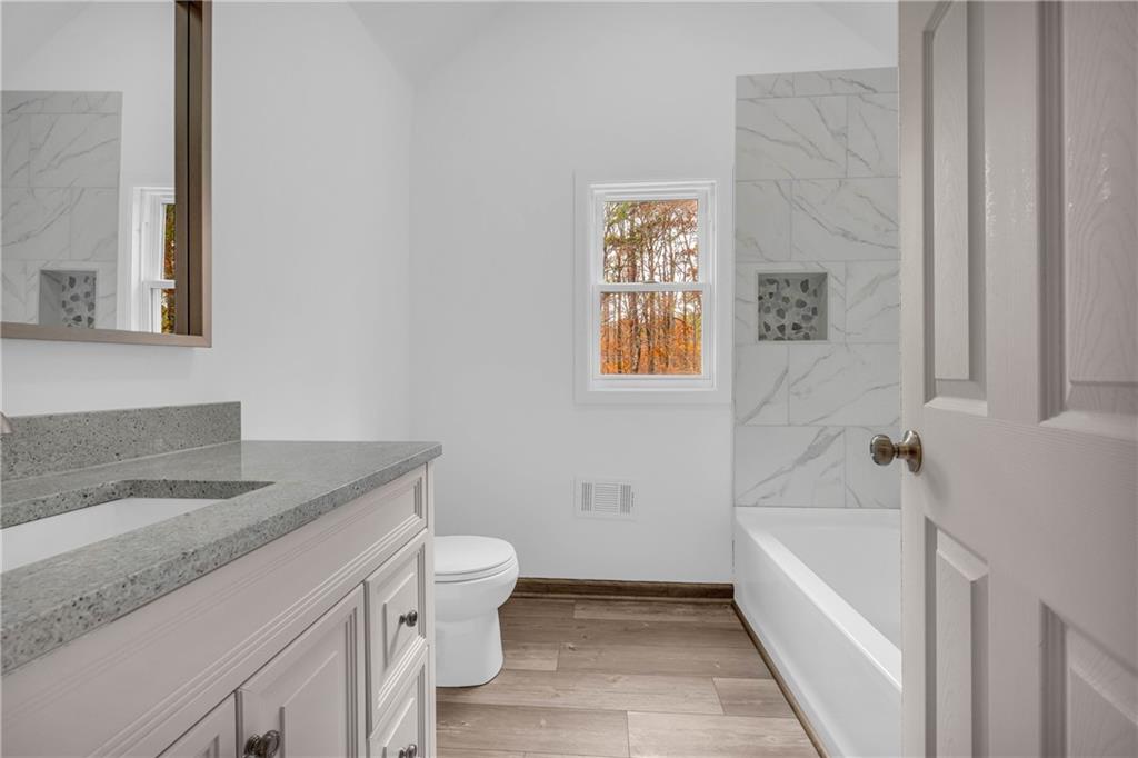 2885 Callie Still Road Lawrenceville, GA 30045 - Photo 58 of 79 a bathroom with a granite countertop sink toilet and bathtub