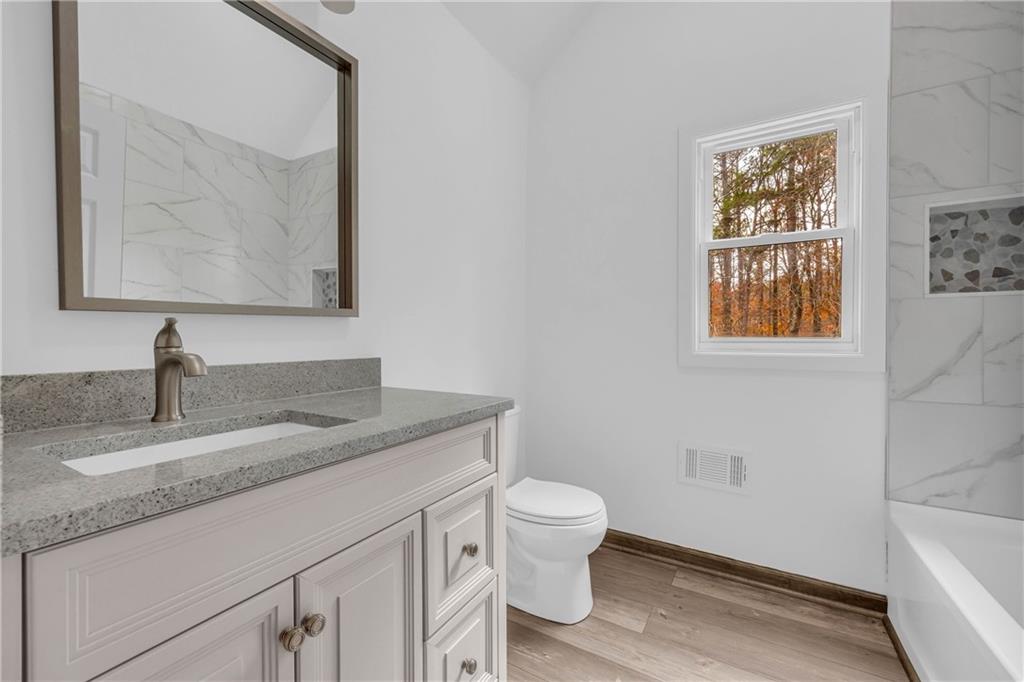 2885 Callie Still Road Lawrenceville, GA 30045 - Photo 59 of 79 a bathroom with a granite countertop toilet sink and mirror