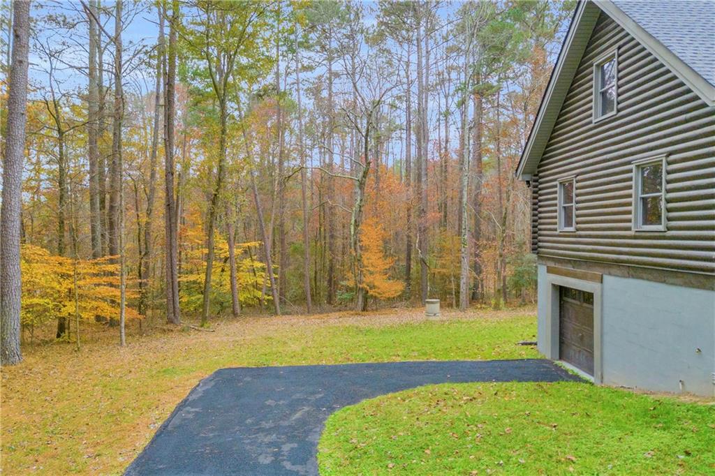 2885 Callie Still Road Lawrenceville, GA 30045 - Photo 6 of 79 a view of swimming pool with lawn chairs and large trees