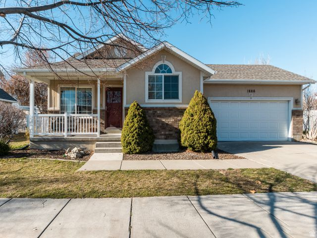 1446 West 1450 North Layton, UT 84041 - Photo 1 of 16 Exterior featuring a covered porch with white railing, stone accents, and a two-car garage