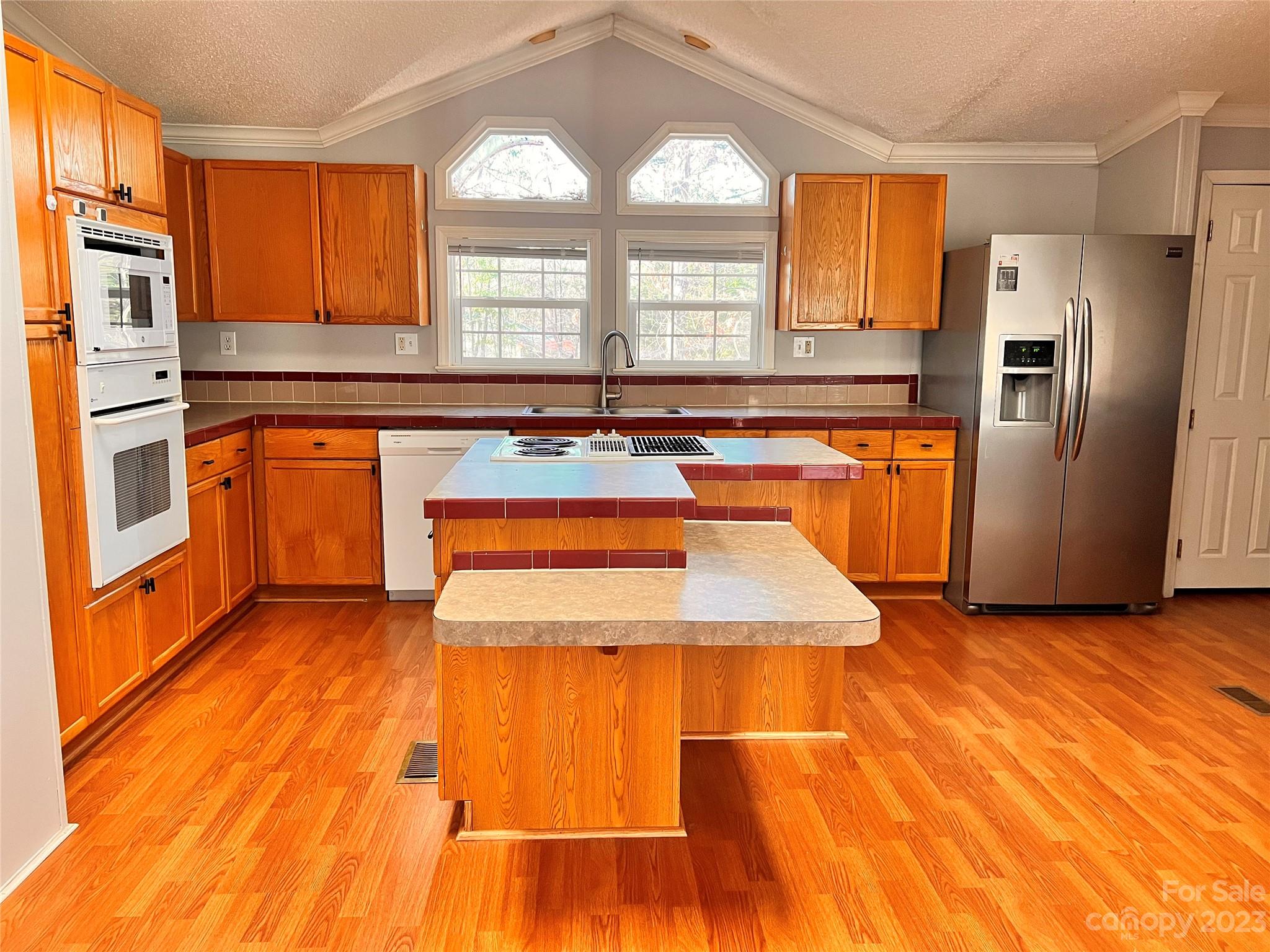 1864 Coopers Gap Road Rutherfordton, NC 28139 - Photo 16 of 46 a kitchen with stainless steel appliances granite countertop a refrigerator a sink dishwasher a stove and white countertops with wooden floor