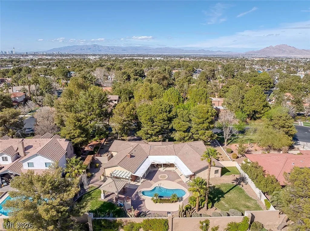 9 Quail Run Road Henderson, NV 89014 - Photo 51 of 57 An aerial panorama reveals a private backyard oasis with an in-ground pool surrounded by lush landscaping and mature trees.