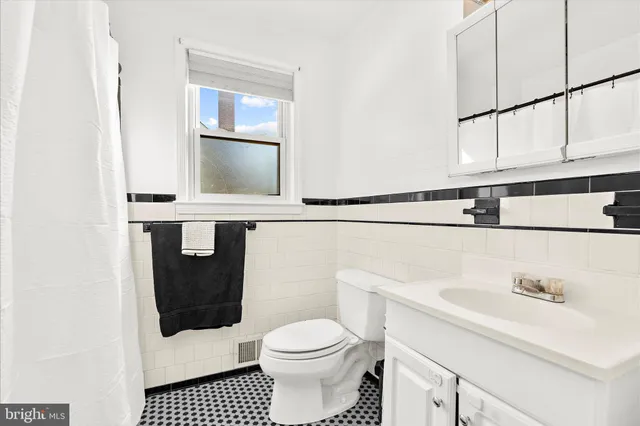 a white toilet sitting next to a bathroom sink and a mirror