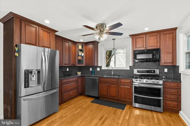 a living room with stainless steel appliances kitchen island granite countertop furniture and a large window